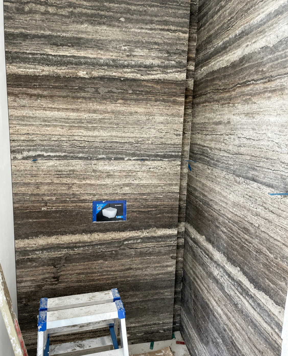 Salle de bain en cours de réalisation avec murs habillés de pierre naturelle veinée